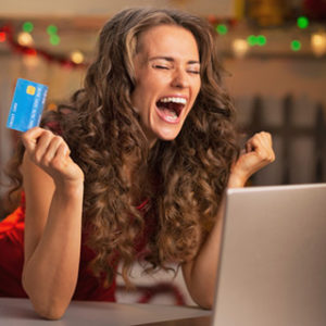 happy-young-woman-holding-credit-card-at-computer-and-rejoicing_web